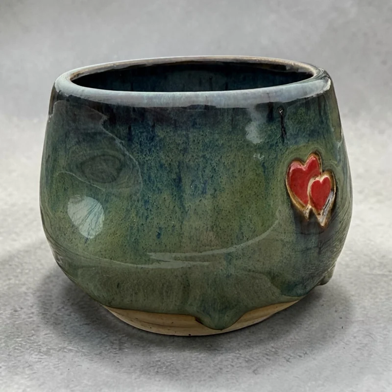 Handmade ceramic cup – green glaze with heart detail